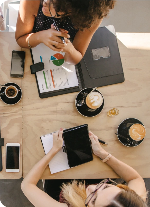 Colleagues collaborating at a table with fresh coffee.