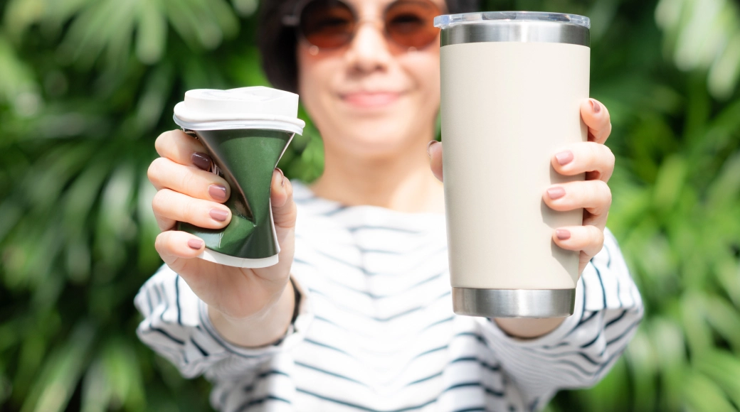 Hands holding a freshly poured cup of coffee.
